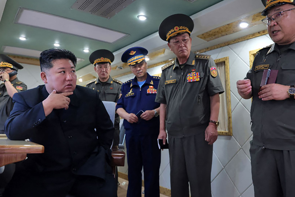 North Korean leader Kim Jong Un (l.) oversaw Saturday's test launch of two new air defense missiles as tensions escalate with the South.
