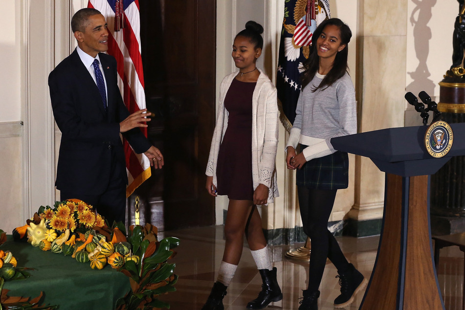 Sasha (c.) and Malia (r.) are pictured with their father, former President Barack Obama, at the White House.