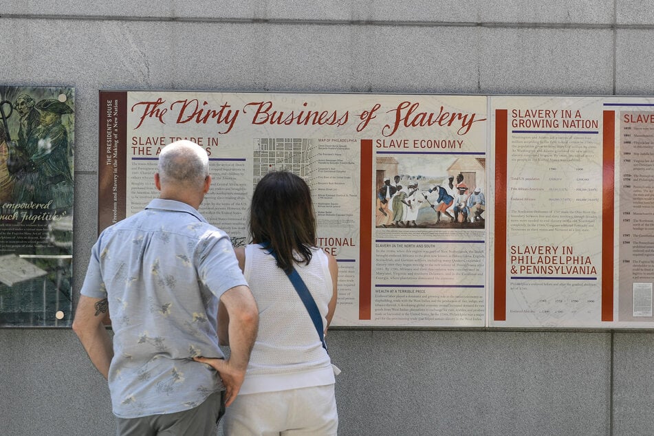 Tourists look at a display entitled The Dirty Business of Slavery at the President's House in Philadelphia, Pennsylvania, on August 9, 2025.