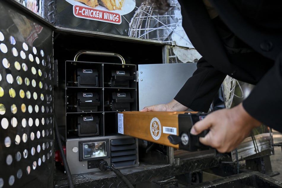 A person pulls out a battery of an electric battery powered food cart in Flushing Meadows-Corona Park on July 23, 2026.