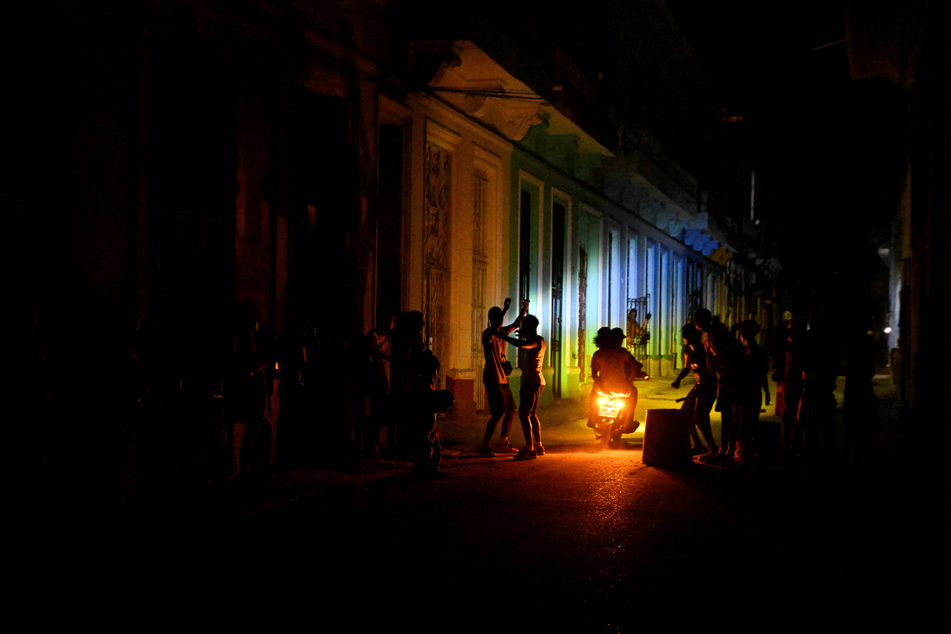 People gather on a street in Havana during a blackout as Cuba's national electric grid collapsed on March 16, 2026.