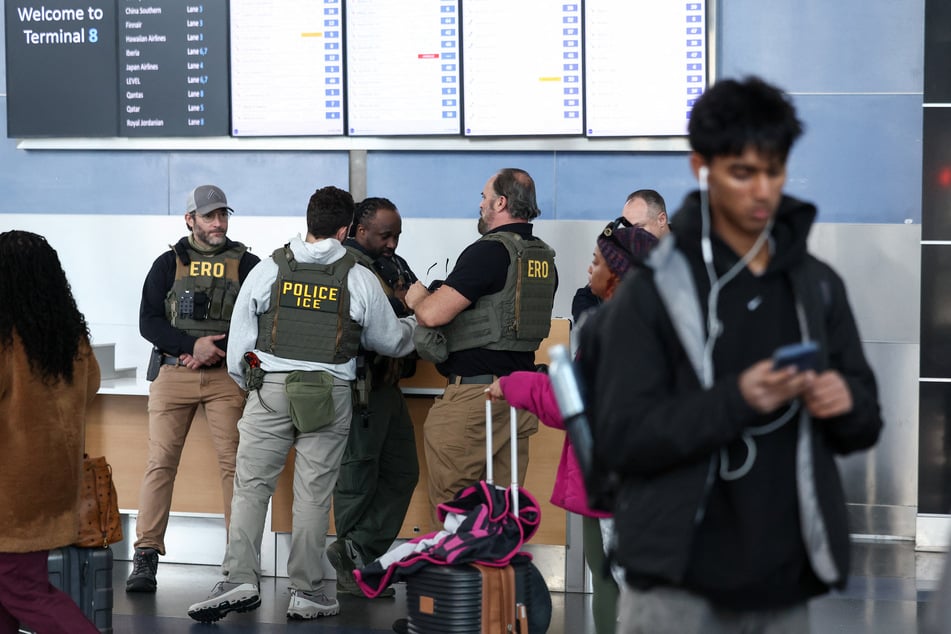 Federal law enforcement agents, including some with Immigration and Customs Enforcement (ICE), stand inside John F. Kennedy International Airport in New York, on Monday.