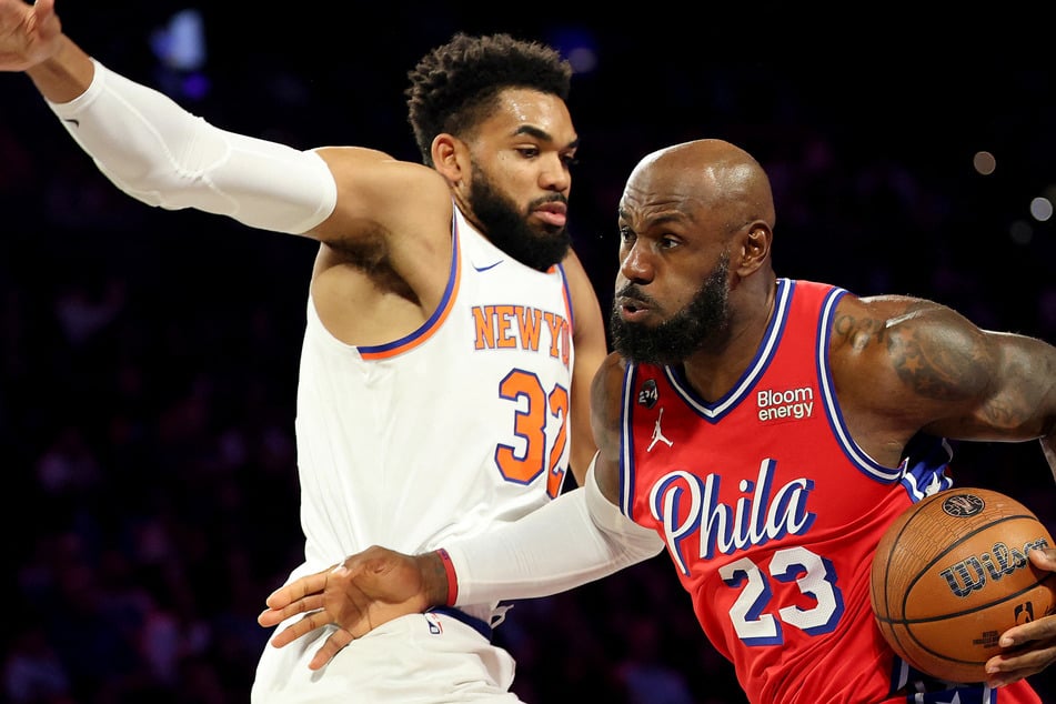 LeBron James (r.) of the Philadelphia 76ers drives against Karl-Anthony Towns of the New York Knicks during the first half of an Emirates NBA Cup game on Friday in Philadelphia, Pennsylvania. LeBron lead the Sixers to a 98-93 victory.