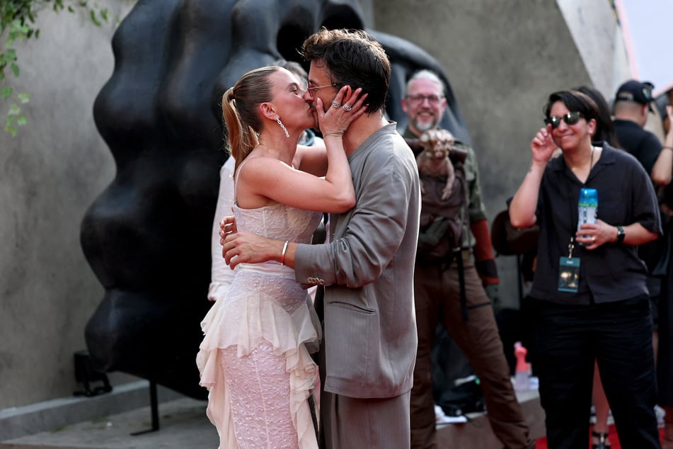 Scarlett Johansson (l.) and co-star Jonathan Bailey shared another viral kiss during Monday's premiere of Jurassic World Rebirth.