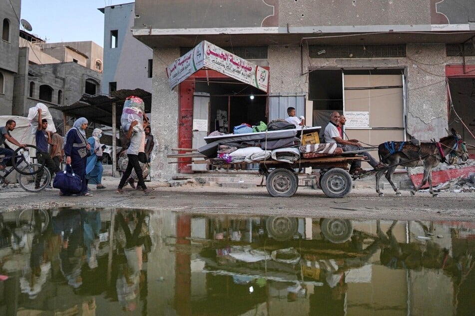Displaced Palestinians leave an area in east Khan Younis after the Israeli army issued a new evacuation order for parts of the city and Rafah, in the southern Gaza Strip.