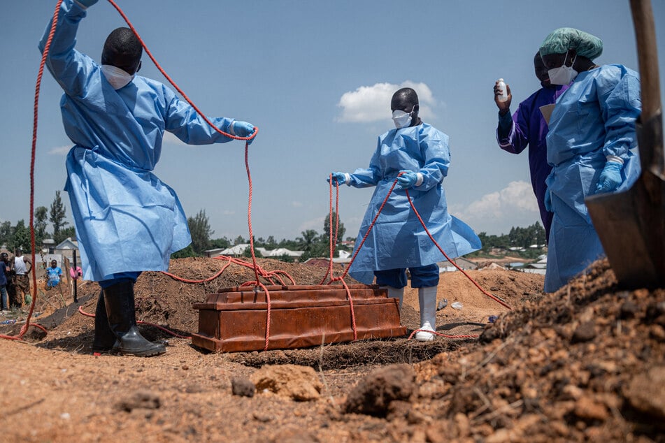 Teams from the International Federation of the Red Cross and Red Crescent Societies prepare for the burial of an orphan who died from Ebola at Mbiyo cemetery in Bunia, Ituri Province, DR Congo, on June 19, 2026.