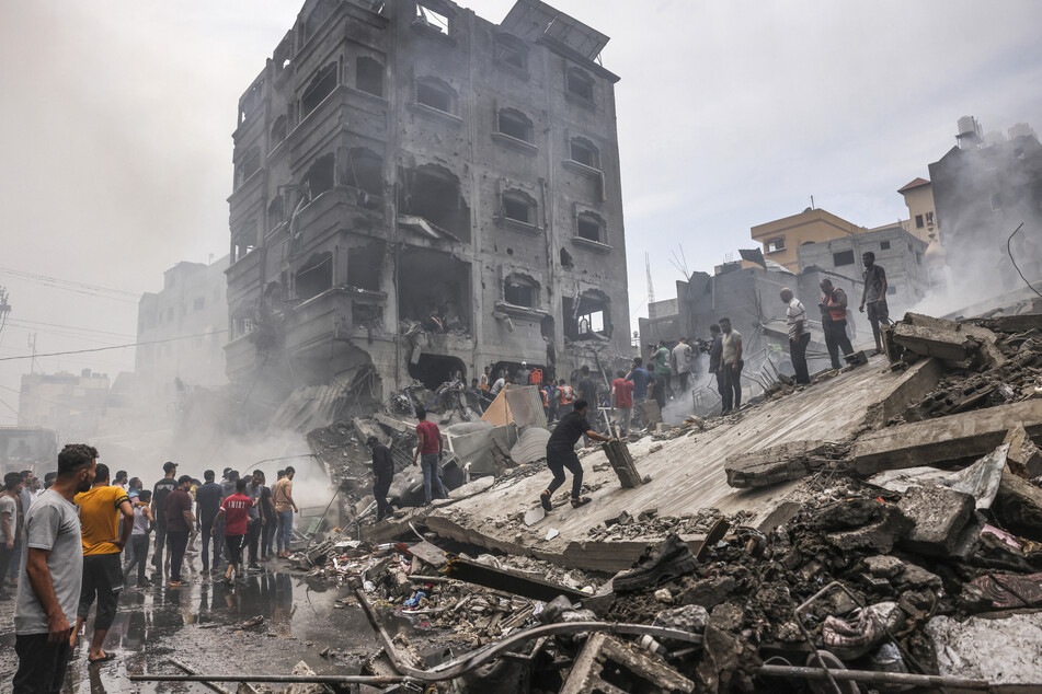 Palestinians search for survivors after an Israeli airstrike on buildings in the refugee camp of Jabalia in the Gaza Strip on October 9, 2023.