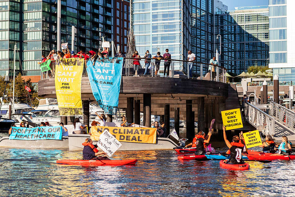 Virginians protest at Senator Joe Manchin's houseboat, Almost Heaven, in the Washington marina in support of passing the spending package.