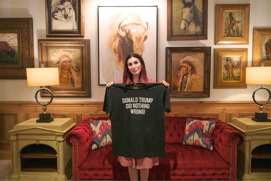 Laura Loomer holds a T-shirt she designed with the words "Donald Trump Did Nothing Wrong" at The Villages, Florida, in September 2024.