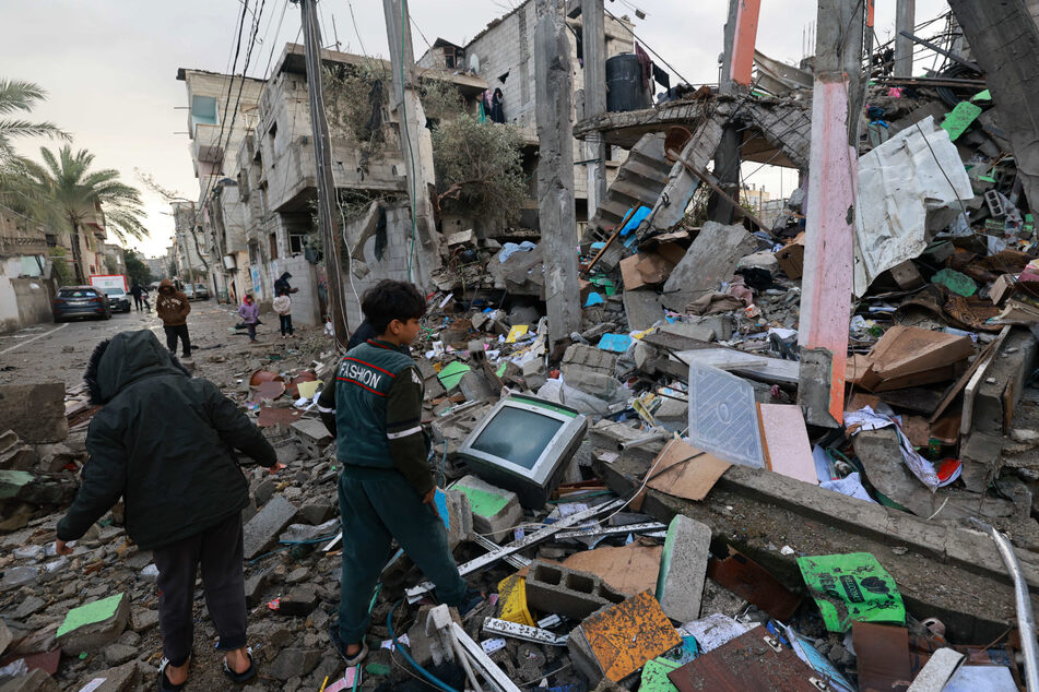 Children stand amid the rubble of a building destroyed by Israeli bombing in Rafah in the southern Gaza Strip on January 27.