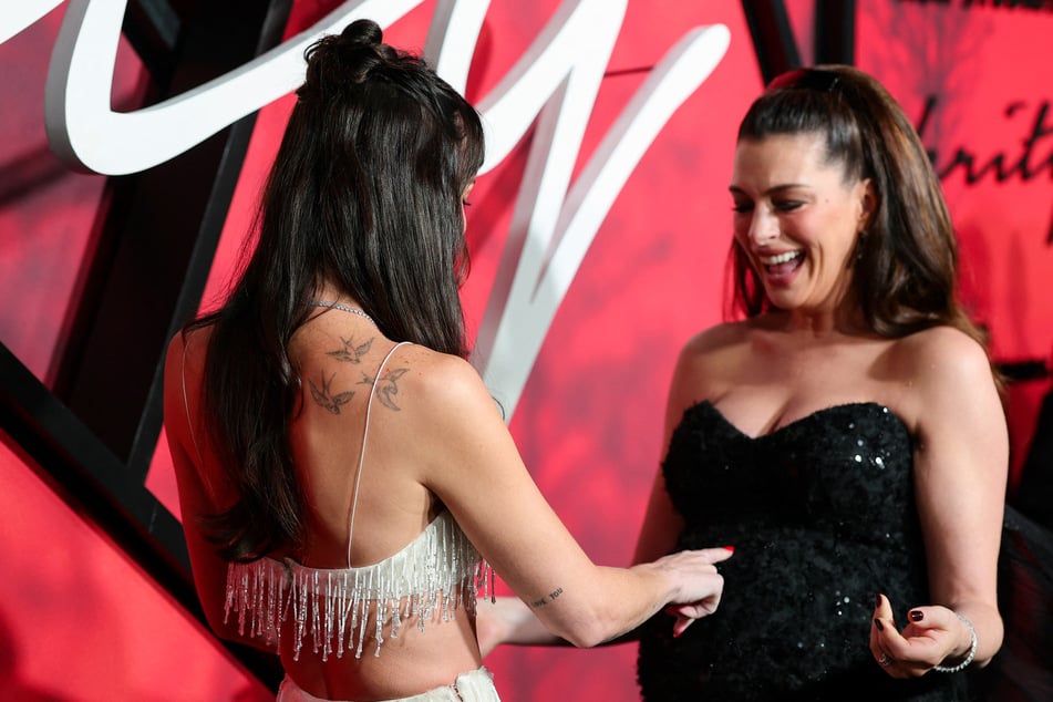 Dakota Johnson (l.) had an adorable reaction to Anne Hathaway's baby bump.