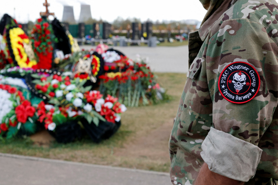 A man visits the grave of Dmitry Utkin, a commander of the Wagner mercenary group, in Moscow, Russia, while marking 40 days since Utkin and the group's chief Yevgeny Prigozhin's death.