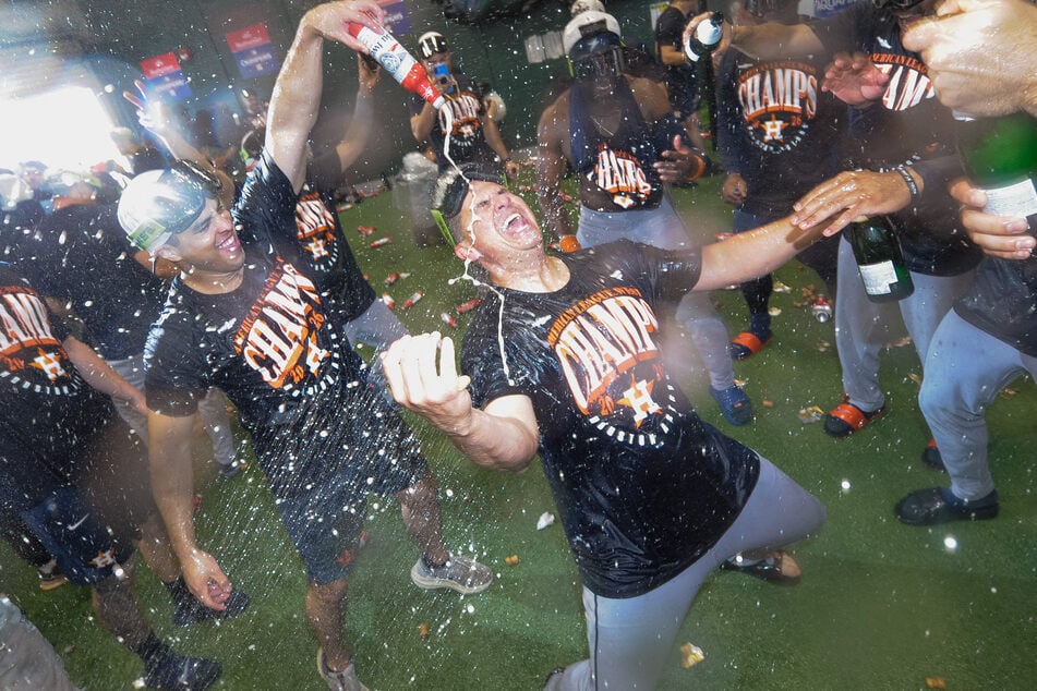 Members of the Houston Astros celebrate with champagne after winning the AL West on the final game of the season against the Athletics at Sutter Health Park.