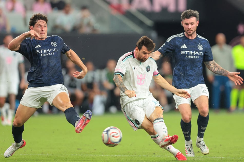 Inter Miami CF forward Leo Messi (c.) shoots the ball defended by New York City midfielder Aiden O'Neill (r.) and defender Nico Cavallo (l.) during the first half at Nu Stadium.