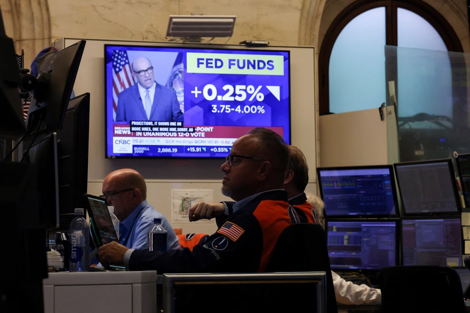 A television displays news of the Federal Reserve's interest rate hike as traders work on the floor of the New York Stock Exchange on September 16, 2026.