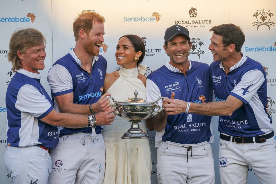 Prince Harry's (second from l.) decision to bring a camera crew and his wife Meghan (c.) to a Sentebale polo fundraiser was criticized by the charity's chairperson.
