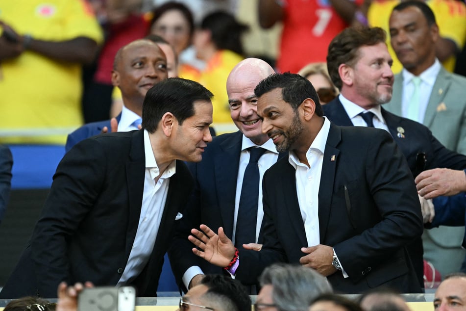 FIFA President Gianni Infantino (m) speaks with Secretary of State Marco Rubio (l) and FBI Director Kash Patel (r) ahead of a World Cup match between Colombia and Portugal.