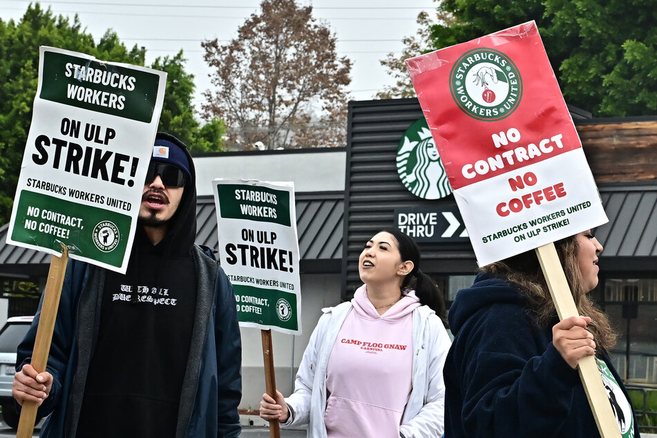 Starbucks workers strike outside a location in Los Angeles, California, to demand collective bargaining agreements on December 24, 2024.