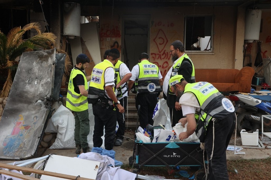 Zaka volunteers search through the debris in Kibbutz Kfar Aza near the border with the Gaza Strip.