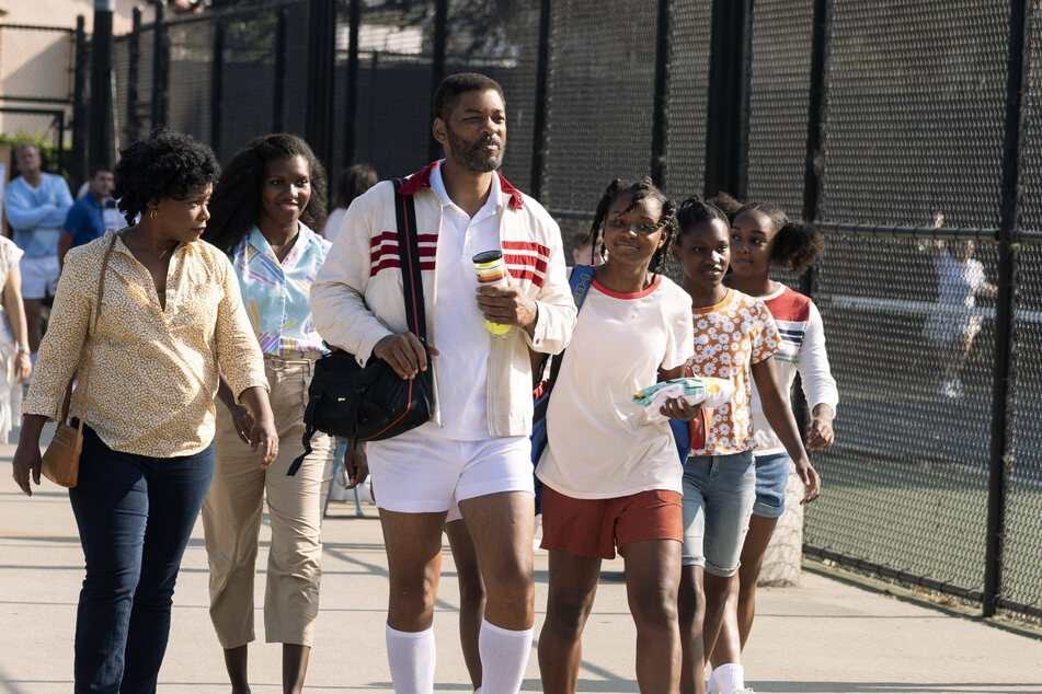 Will Smith (c.) portrays Richard Williams, the father of tennis superstars Venus and Serena Williams, in the biopic King Richard.
