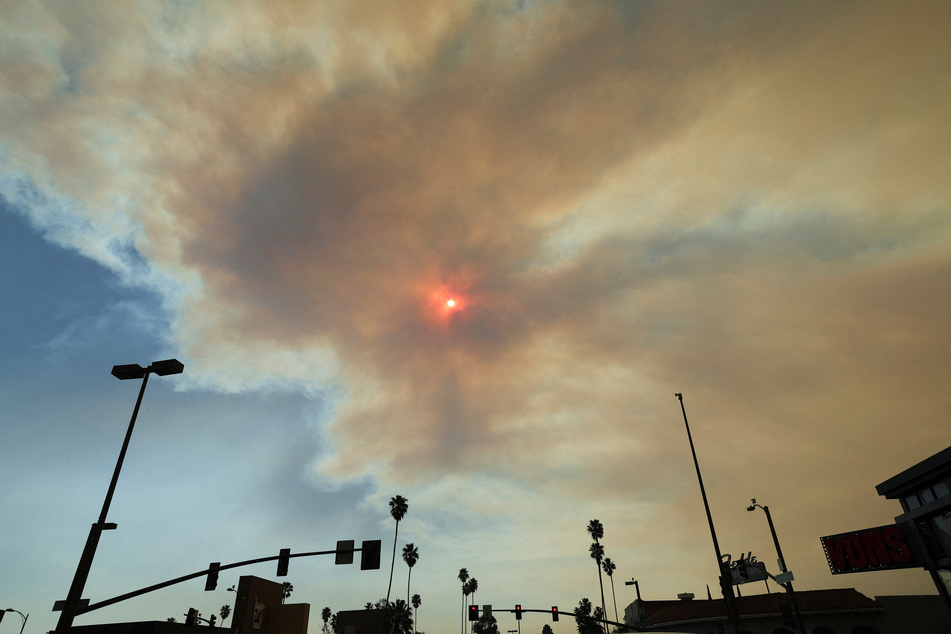 The sun is visible through smoke after the Eaton Fire tore through a neighborhood in Pasadena, California, on January 9, 2025.