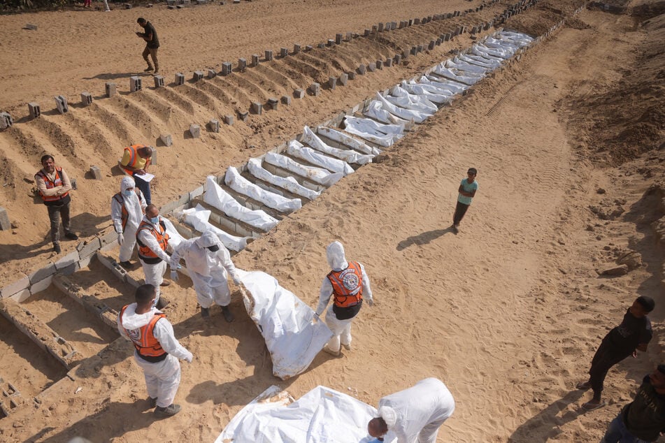Health and civilian workers conduct a mass burial of Palestinians at a cemetery in Khan Younis, in the southern Gaza Strip, on November 10, 2025.