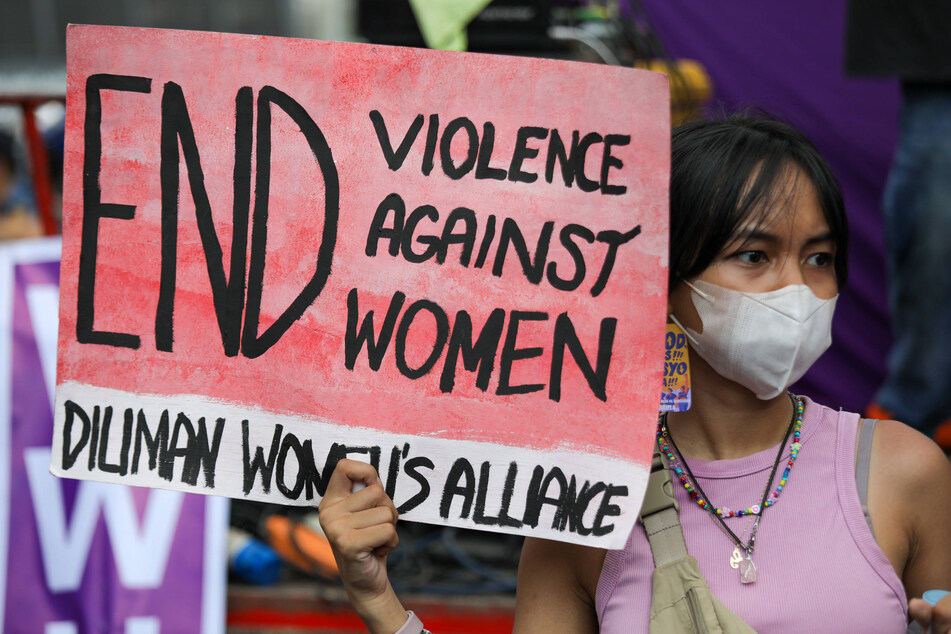 A woman holds a sign as protesters rally to mark International Women's Day in Manila, Philippines on March 8, 2023.