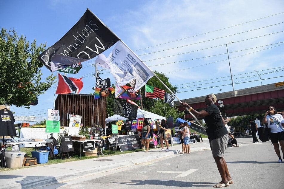 A woman waves a flag calling for reparations for the 1921 Tulsa Massacre in Tulsa, Oklahoma.
