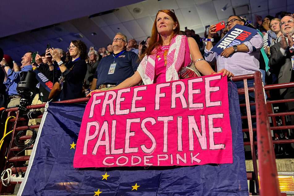 CODEPINK co-founder Jodie Evans raises a "Free Free Palestine" banner on the second night of the Democratic National Convention at Chicago's United Center.