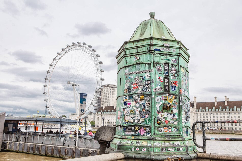 Stickers on a green booth near Westminster pier in London, UK.