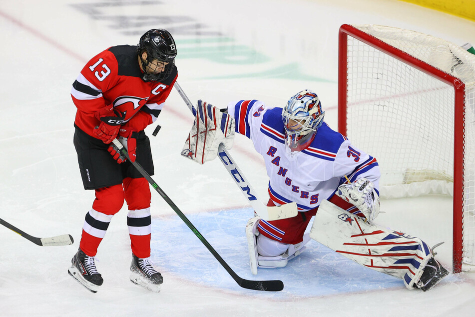 Devils center Nico Hischier (13) deflects the puck on New York Rangers goaltender Igor Shesterkin (31)