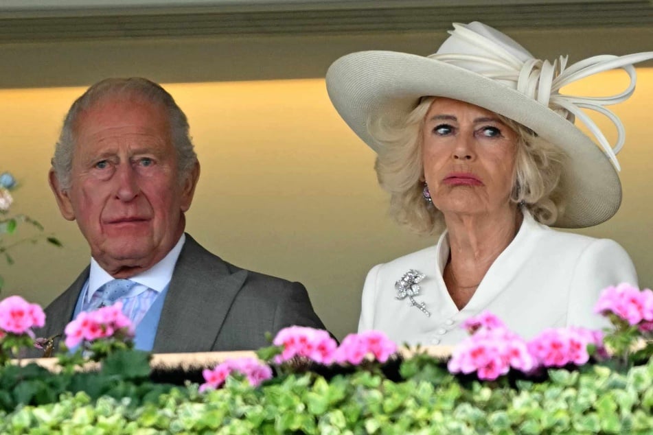Britain's Queen Camilla (R) spoke about the difficulty of not revealing that King Charles III (L) had cancer when she visited a support charity shortly after his diagnosis.