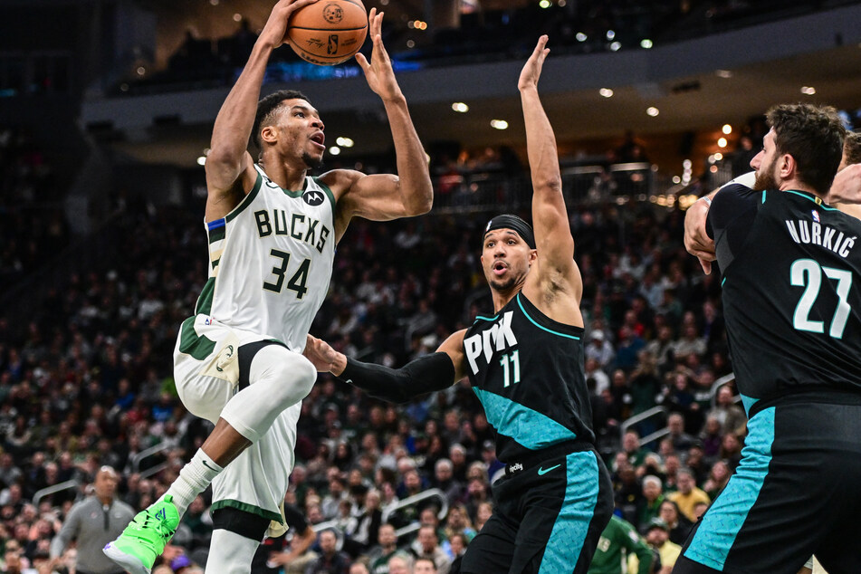 Milwaukee Bucks forward Giannis Antetokounmpo takes a shot against Portland Trail Blazers guard Josh Hart in the second quarter at Fiserv Forum.