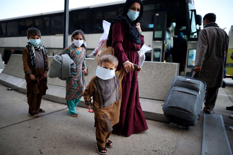 People seeking refuge board buses that will take them to a processing center at Dulles International Airport in Virginia after being evacuated from Kabul following the Taliban takeover of Afghanistan, on August 27, 2021.