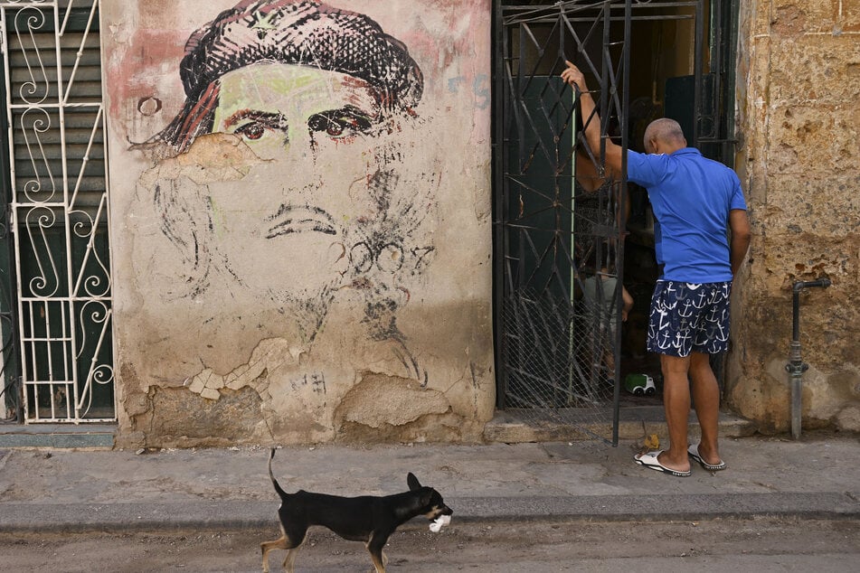 A man enters his home next to a mural depicting Argentine-born revolutionary leader Ernesto "Che" Guevara after a power outage in Havana on March 5, 2026.