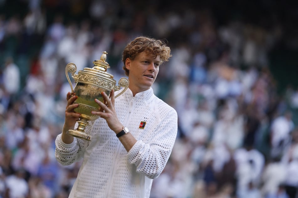 Italy's Jannik Sinner celebrates with the Wimbledon trophy after winning his final match against Germany's Alexander Zverev on June 12, 2026.