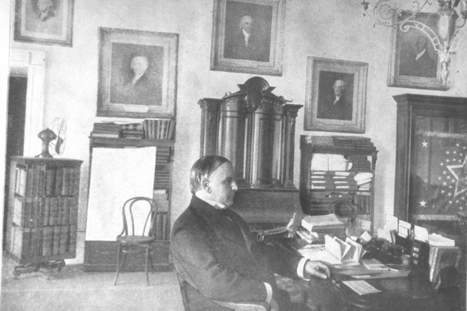 President William McKinley sits at his desk in the White House in a photograph from the year 1899.
