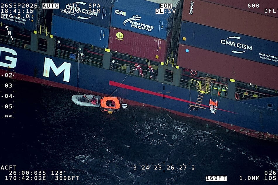 This handout image taken on September 26 shows survivors being rescued by crew members of a container ship. The rescue came about 18 hours after their encounter with the whale.