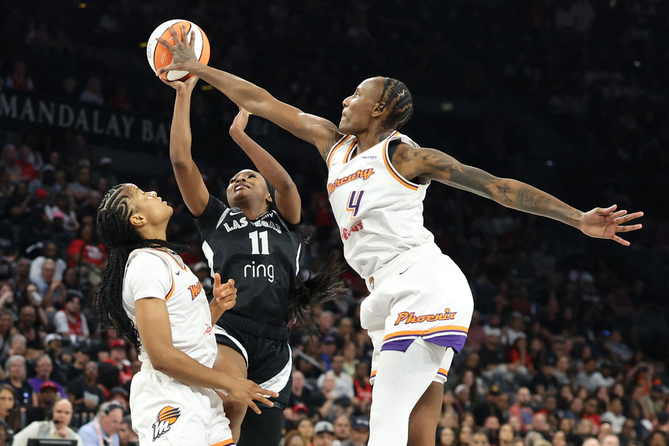 Dana Evans (c.) of the Las Vegas Aces shoots the ball between Monique Akoa Makani (l.) and Natasha Mack of the Phoenix Mercury in the second quarter of Game One of the 2025 WNBA Finals at Michelob ULTRA Arena on October 3, 2025.