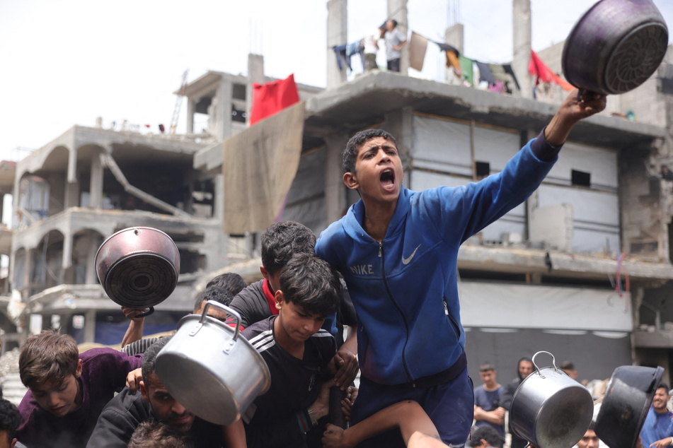 Palestinian children wait for their food rations outside a distribution center in Beit Lahia in the northern Gaza Strip on May 15, 2025.