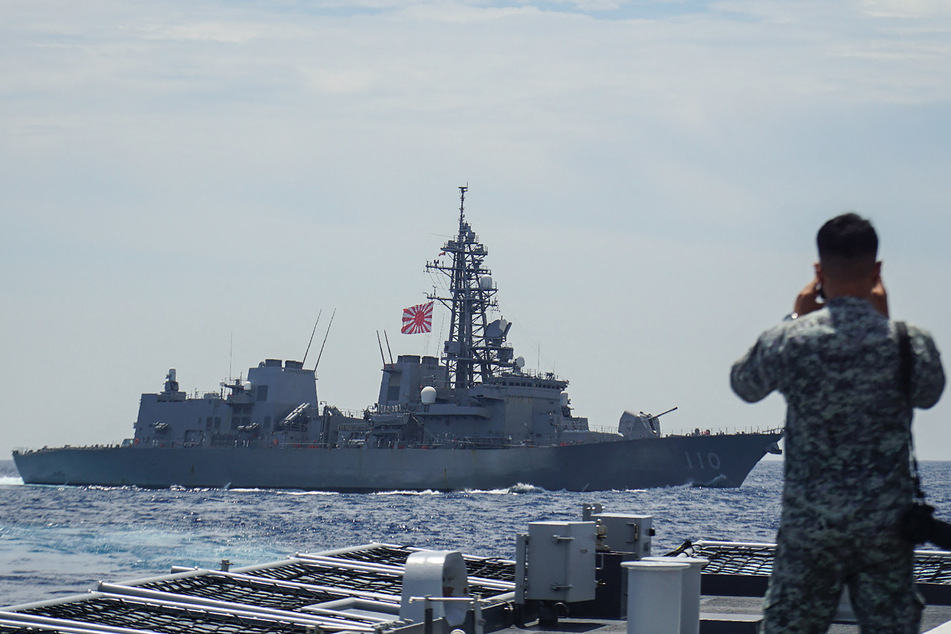 A member of the Philippine Navy looks out at the Japan Maritime Self-Defense Force's destroyer Takanami during a joint maritime exercise in the South China Sea on June 14, 2025.