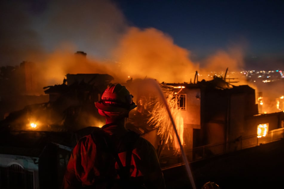 Firefighters battle the Norte Fire while it burns a house in San Juan Capistrano, California, on October 16, 2026.
