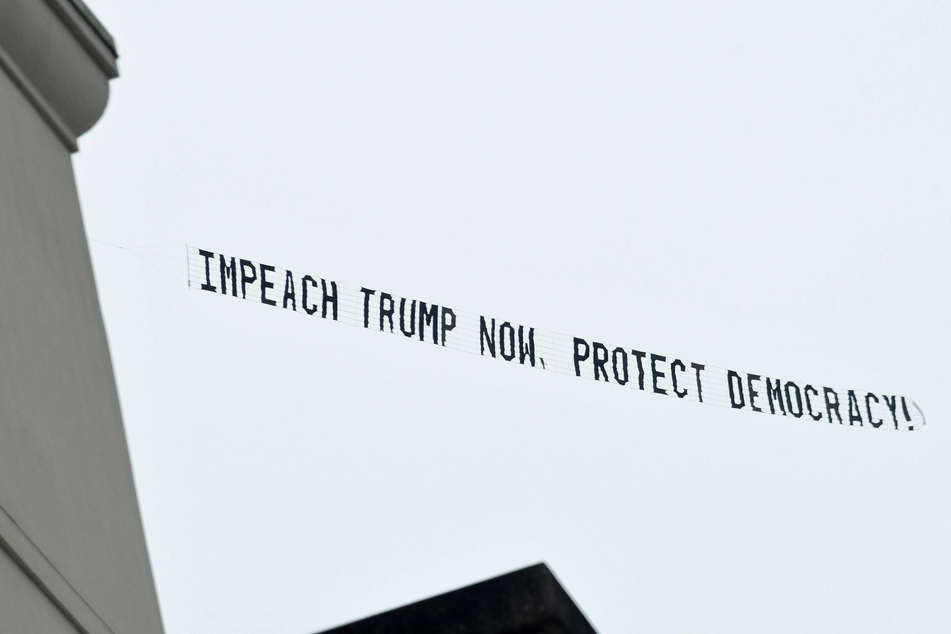 A banner towed by a plane flying in Orlando, Florida, calls for the impeachment of Donald Trump.