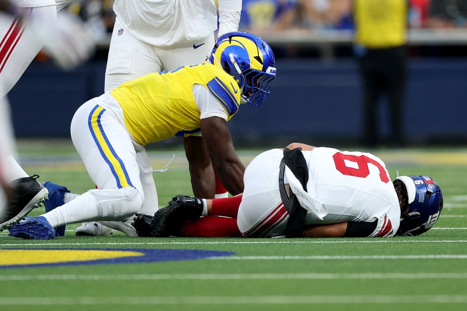 Jaxson Dart of the New York Giants lays on the ground after being tackled by Byron Young of the Los Angeles Rams during the first quarter of the game at SoFi Stadium on September 21, 2026.