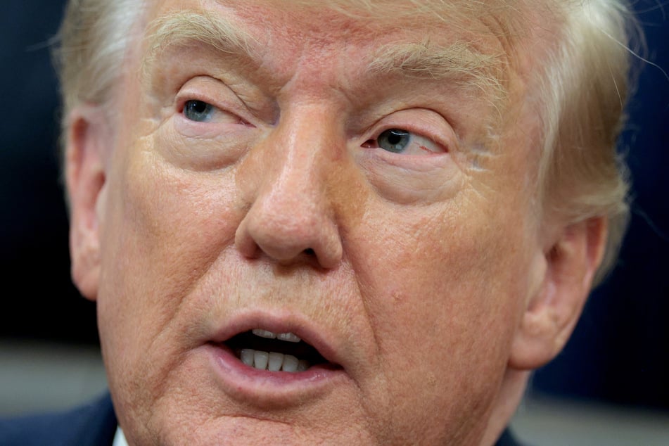 President Donald Trump talks to reporters in the Oval Office. The president is taking aim at various news outlets while claiming he struck a deal with Greenland.