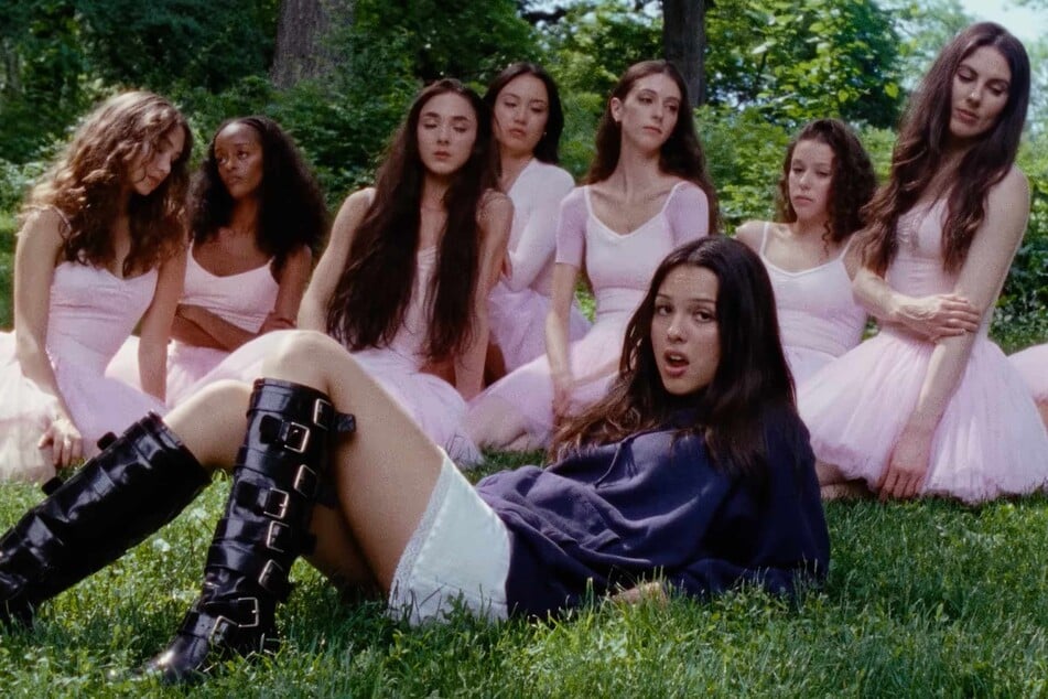 Olivia Rodrigo (front, c) notably featured ballet dancers in the music video for her hit track, stupid song.