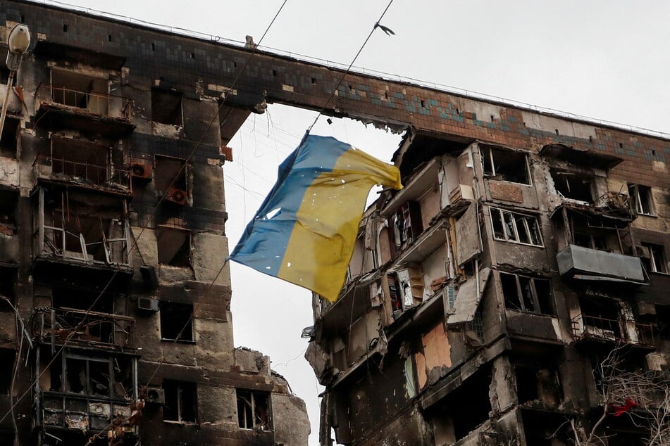 A Ukrainian flag flying in from a destroyed building in Mariupol.