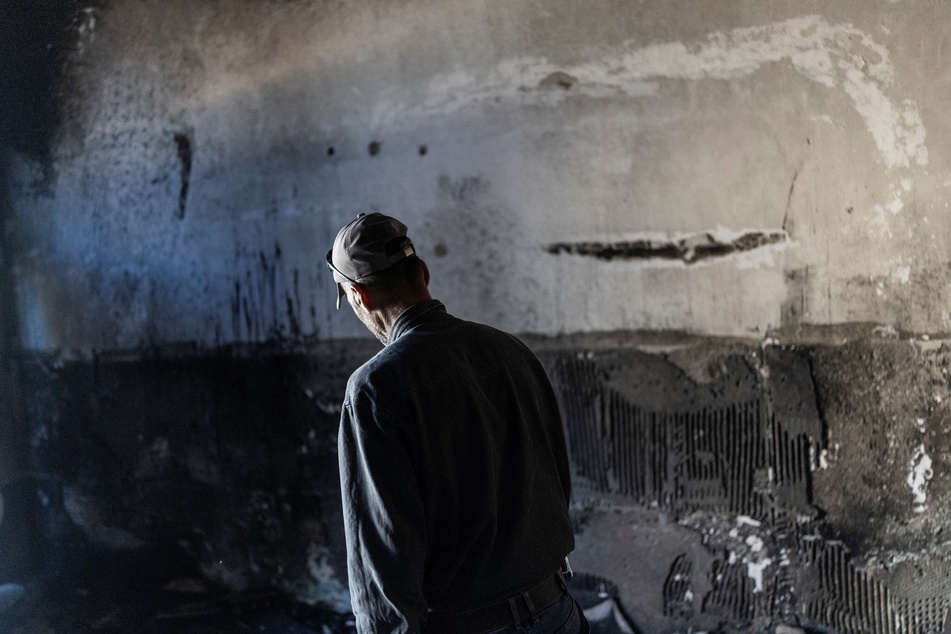 A Palestinian man walks past a charred wall as he inspects the damage inside a mosque burned by Israeli settlers overnight, in the Israeli-occupied West Bank village of Jiljliya, on June 17, 2026.