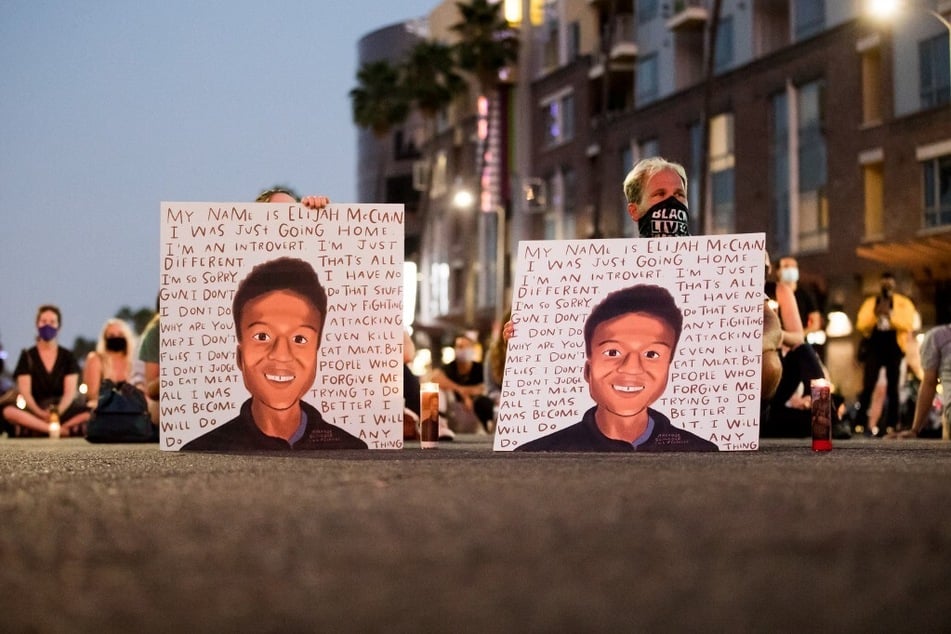 People gather at a candlelight vigil to demand justice for Elijah McClain, who died after being put in a chokehold by police and injected with ketamine by paramedics.