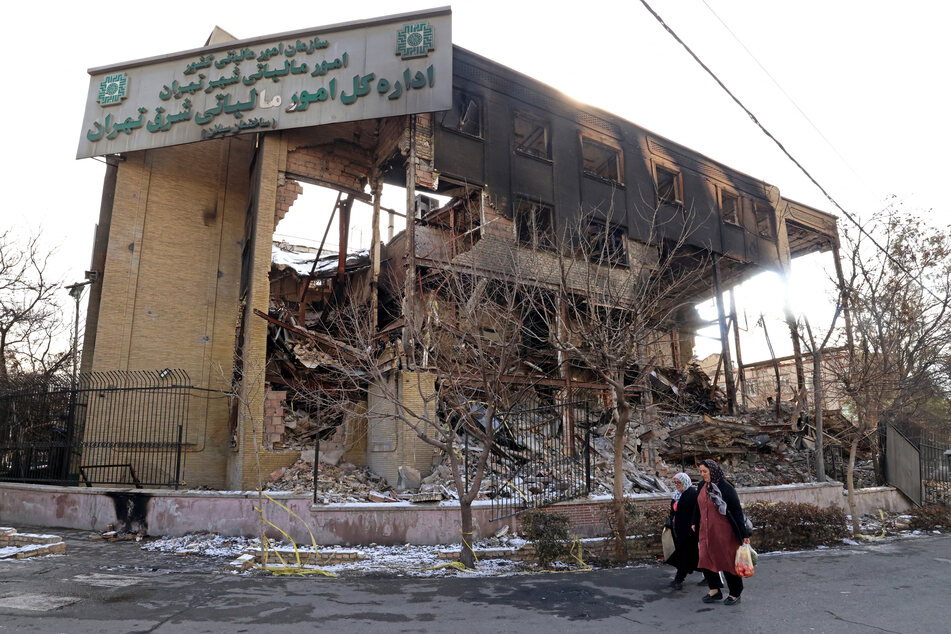 This photograph taken during a tour for foreign media shows women walking past a government building that was burnt during recent public protests, in Tehran on Wednesday.